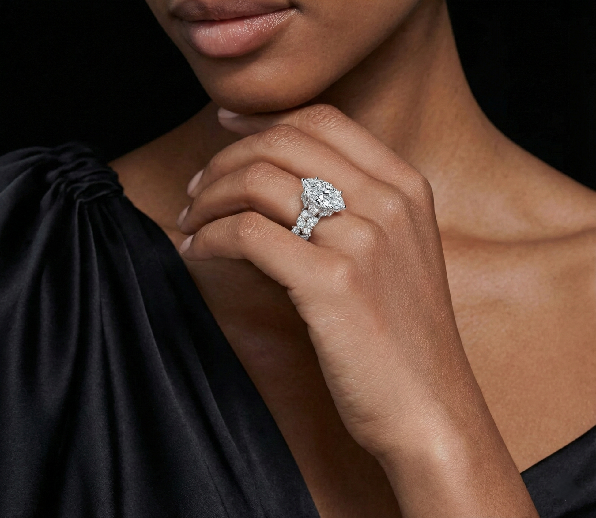 Diamond ring with a marquise-shaped center stone on a black velvet background