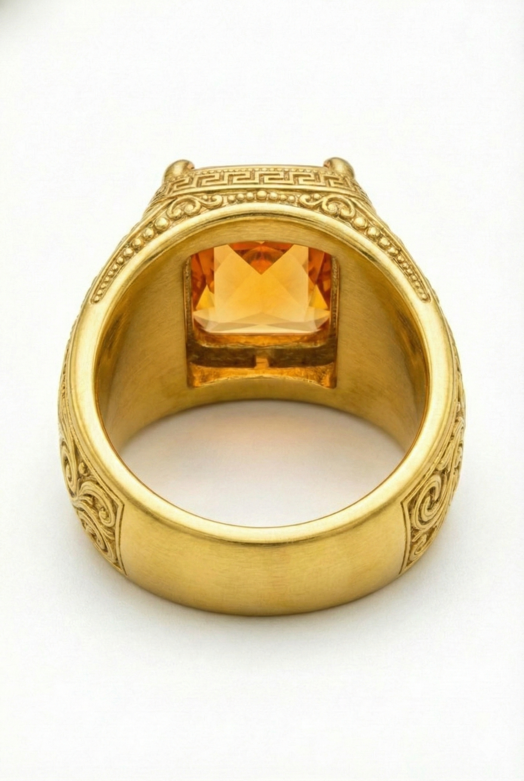 Vintage-style men's gold wedding band featuring classical engravings and a square orange gemstone