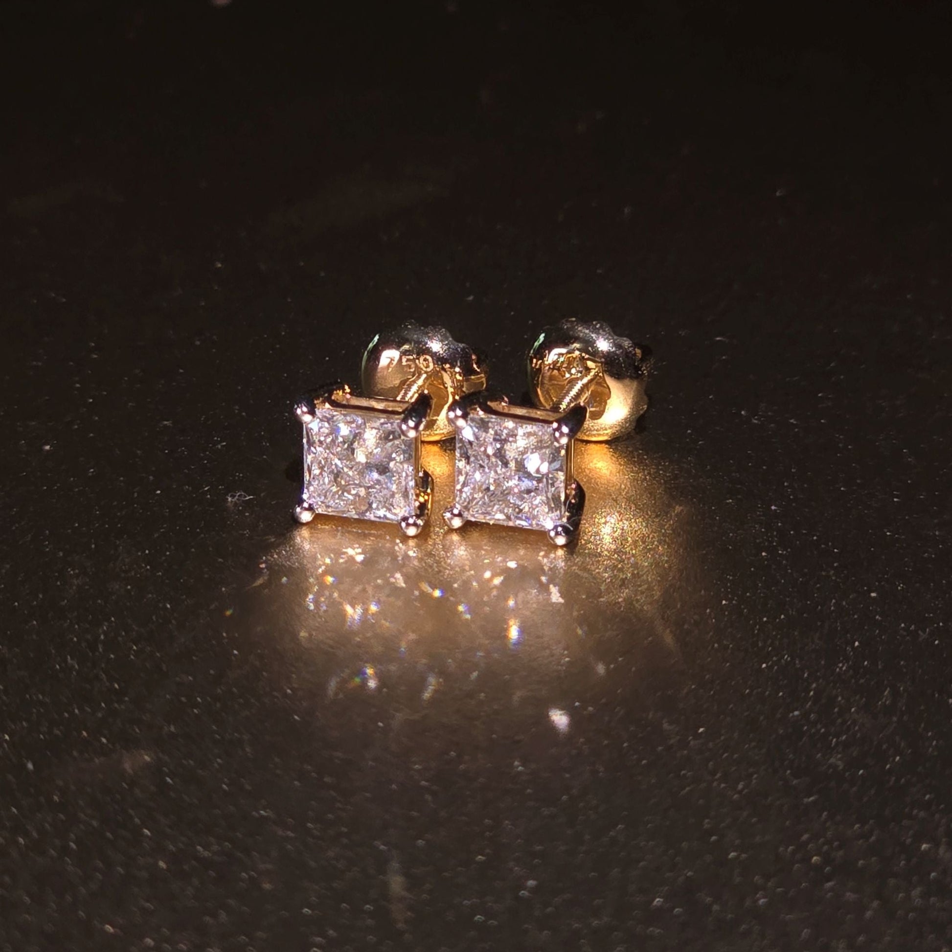 Gold and diamond stud earrings on a black background