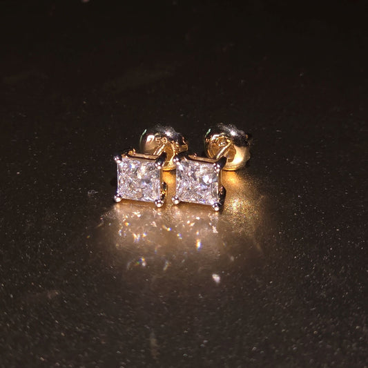 Gold and diamond stud earrings on a black background