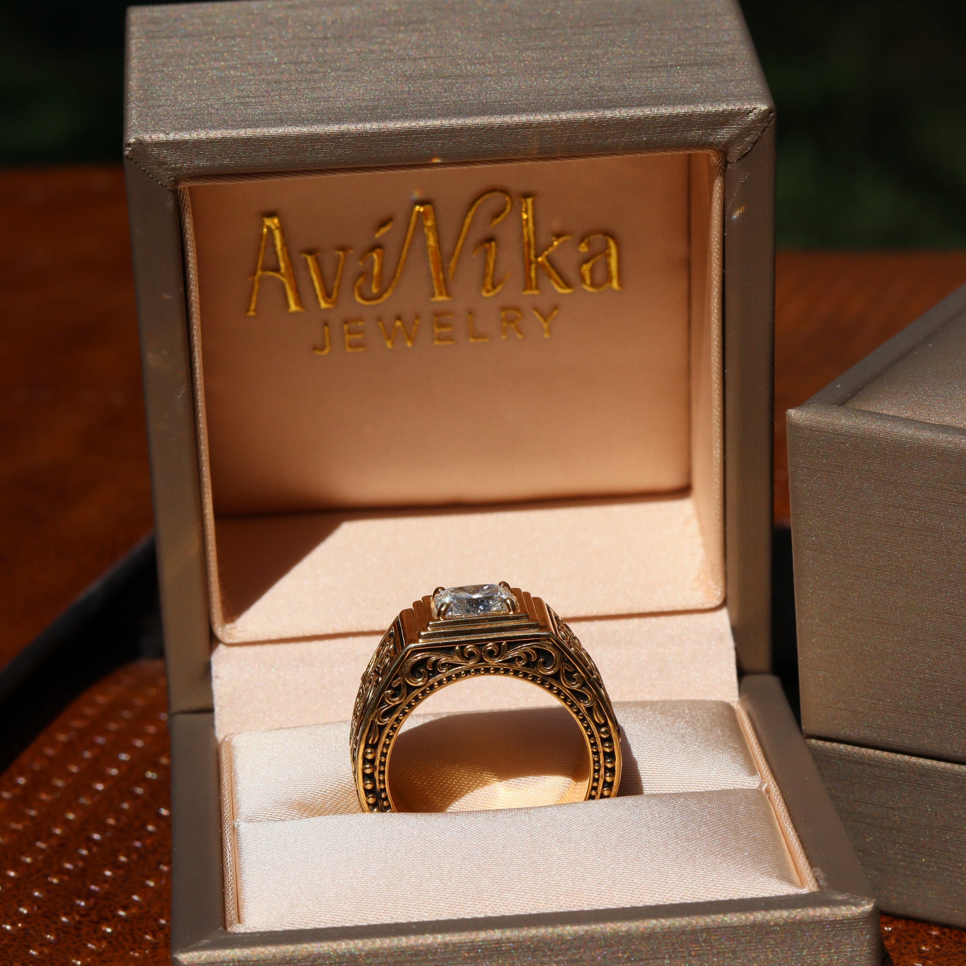 Gold ring in an open jewelry box with 'AviNika Jewelry' branding.